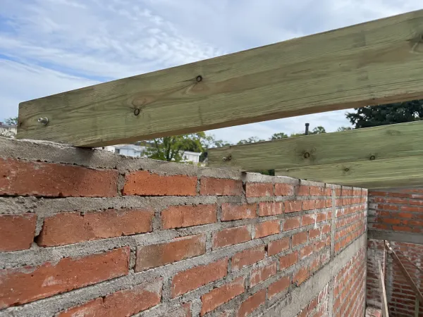 Ilustración: Pérgola con techo de isopanel, tirantes de madera tratada